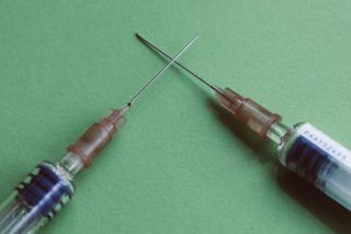crossing syringes on green background
