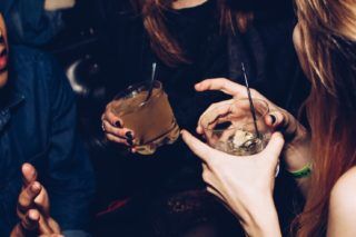 women at party holding drinks